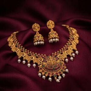 Antique gold-tone temple jewellery set with Lakshmi pendant necklace and matching jhumka pearl drop earrings