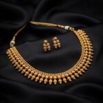 Antique gold-tone beaded drop necklace with textured tassel detailing and matching earrings