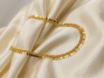 Gold-tone Elakathali leaf necklace on cream fabric – SunShoppers UK