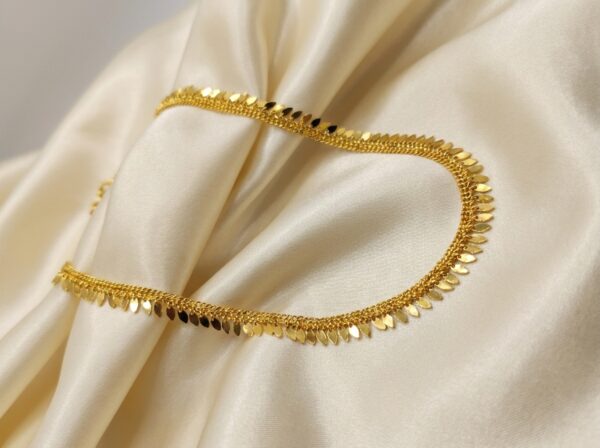 Gold-tone Elakathali leaf necklace on cream fabric – SunShoppers UK