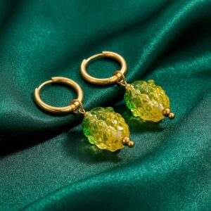 Pineapple charm gold hoop earrings on green fabric