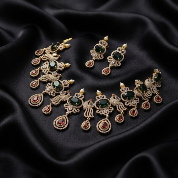 Gold-tone peacock necklace set with cubic zirconia, green and ruby-coloured stones, pearl-effect accents and matching drop earrings on black fabric