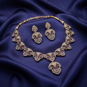Gold-tone purple necklace set with openwork medallions, cubic zirconia, adjustable chain and matching drop earrings on navy fabric