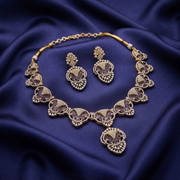 Gold-tone purple necklace set with openwork medallions, cubic zirconia, adjustable chain and matching drop earrings on navy fabric