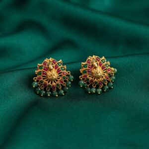 Antique gold-tone peacock stud earrings with ruby-coloured and green stones and green bead drops on green fabric