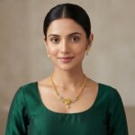 Gold-tone dainty necklace set with Lakshmi coin pendant, cubic zirconia flower medallions, faux pearl drop and matching stud earrings