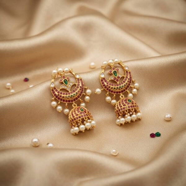 Antique gold-tone chandbali earrings with crescent frame, jhumka drop, ruby-coloured and green stones and faux pearls on champagne fabric