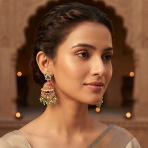 Gold-tone pink Indian statement earrings with floral stud tops, pink dome crescent frame, green bead drops and faux pearls