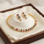 Gold-tone multicolour necklace set with oval coloured stones, cubic zirconia halos and matching drop earrings in a gift box