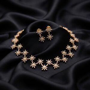 Gold-tone star necklace set with linked cubic zirconia starburst motifs and matching drop earrings on black fabric