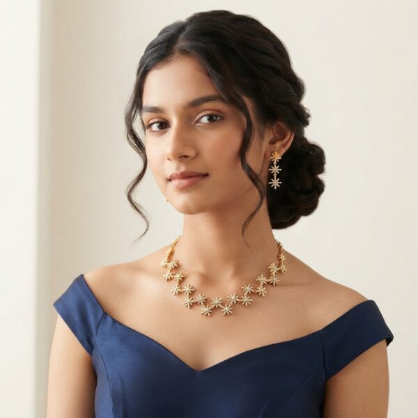 Gold-tone star necklace set with linked cubic zirconia starburst motifs and matching drop earrings