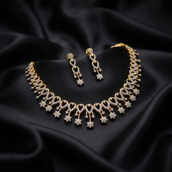 Gold-tone fringe necklace set with cubic zirconia loop motifs, flower charm drops and matching drop earrings on black fabric