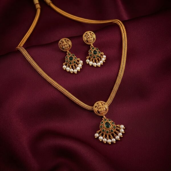Antique gold-tone South Indian chain necklace set with Lakshmi motif, green stone-style pendant and matching pearl-style drop earrings