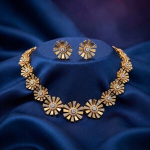 Gold-tone sunburst flower cubic zirconia necklace set with matching stud earrings on navy blue fabric