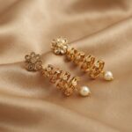 gold-tone tiered drop earrings with kundan-style floral top and pearl-style drop