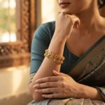 Pair of antique gold-tone Lakshmi coin bangles with temple-style discs and stone-style accents