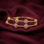 Pair of slim gold-tone American diamond lotus bangles with clear AD-style stones