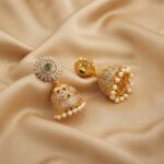 gold-tone sunburst jhumka earrings with AD-style stones and pearl-style drops