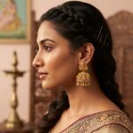Pair of ornate gold-tone filigree jhumka earrings with sparkling accents and bead drops