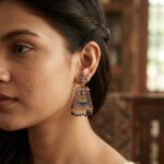 gold-tone temple jewellery earrings with Lakshmi motif and red bead drops