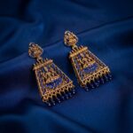 gold-tone temple jewellery earrings with Lakshmi motif and red bead drops