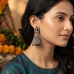 oxidised silver-tone temple jhumka earrings with Lakshmi motif top and maroon bead drops
