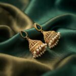 gold-tone filigree jhumka earrings with pearl-style fringe and teardrop stone-style