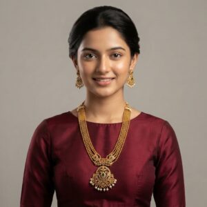Antique gold-tone multi-strand bead temple jewellery necklace set with ornate pendant, pearl-effect drops and matching chandelier earrings on maroon fabric